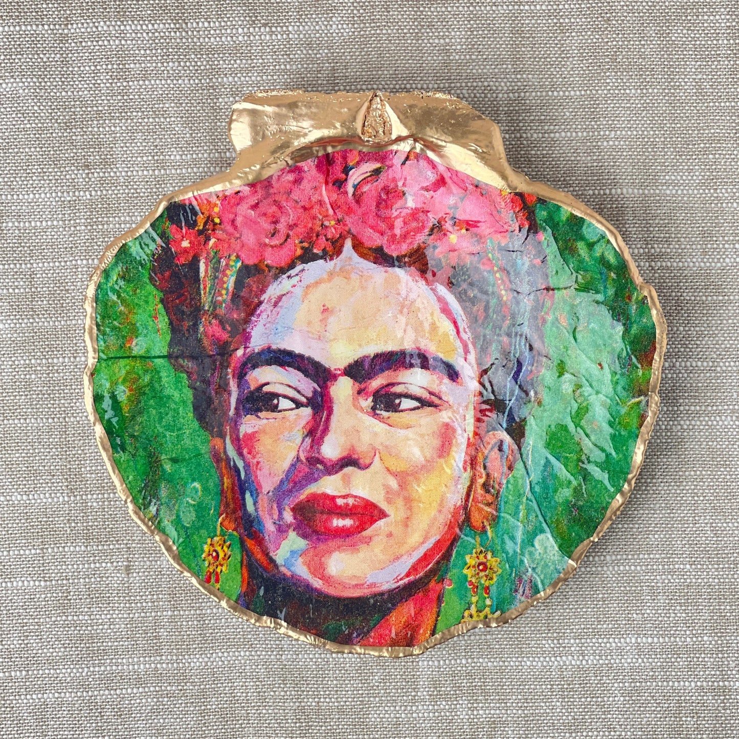 A scallop shell ring dish with a decoupage Frida Kahlo design in multicolor, displayed on a neutral background.