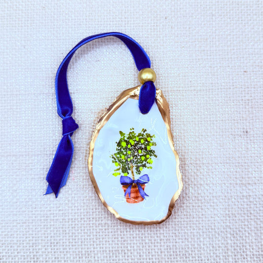 Decorative oyster ornament with a lemon tree design on a white background