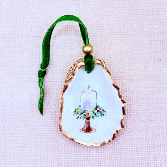 Decorative oyster ornament with a design of a candle and flowers on a light background