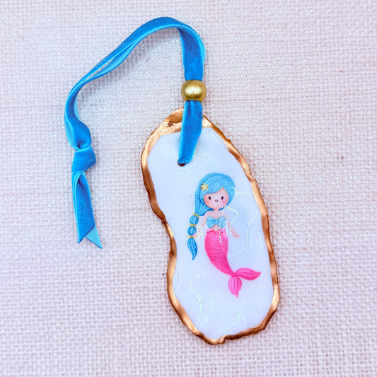 Mermaid-themed christmas oyster ornament with blue ribbon on a light background