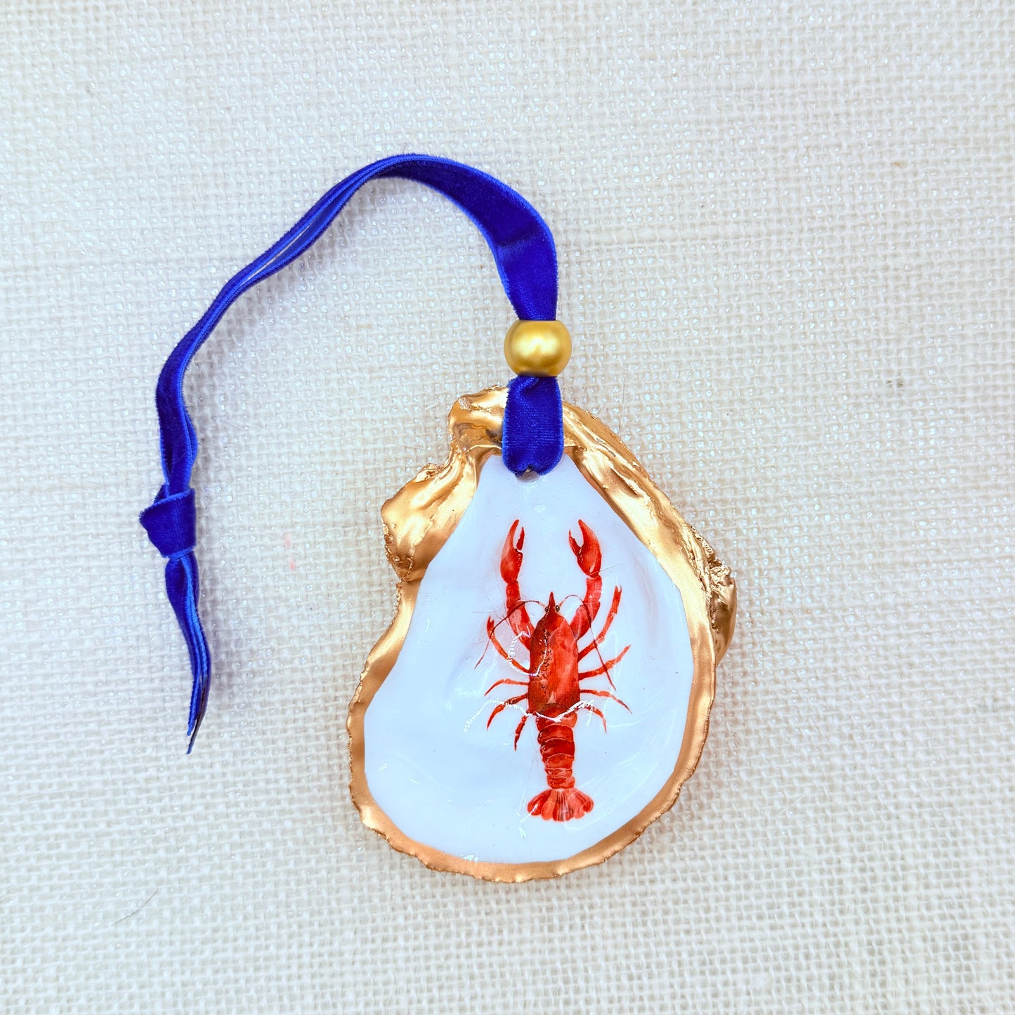 Decorative ornament oyster with a red lobster design on a white background.