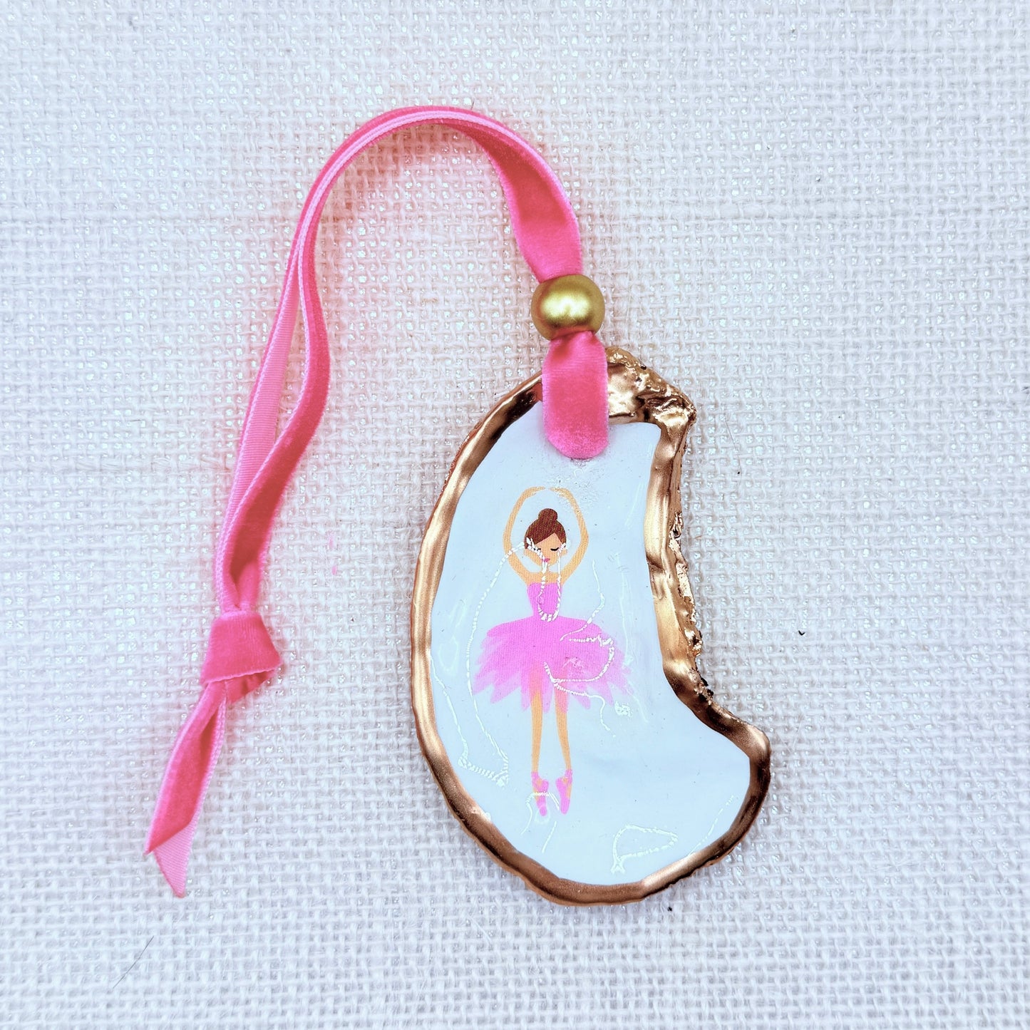 Decorative Christmas ornament with a ballerina design on a neutral background.