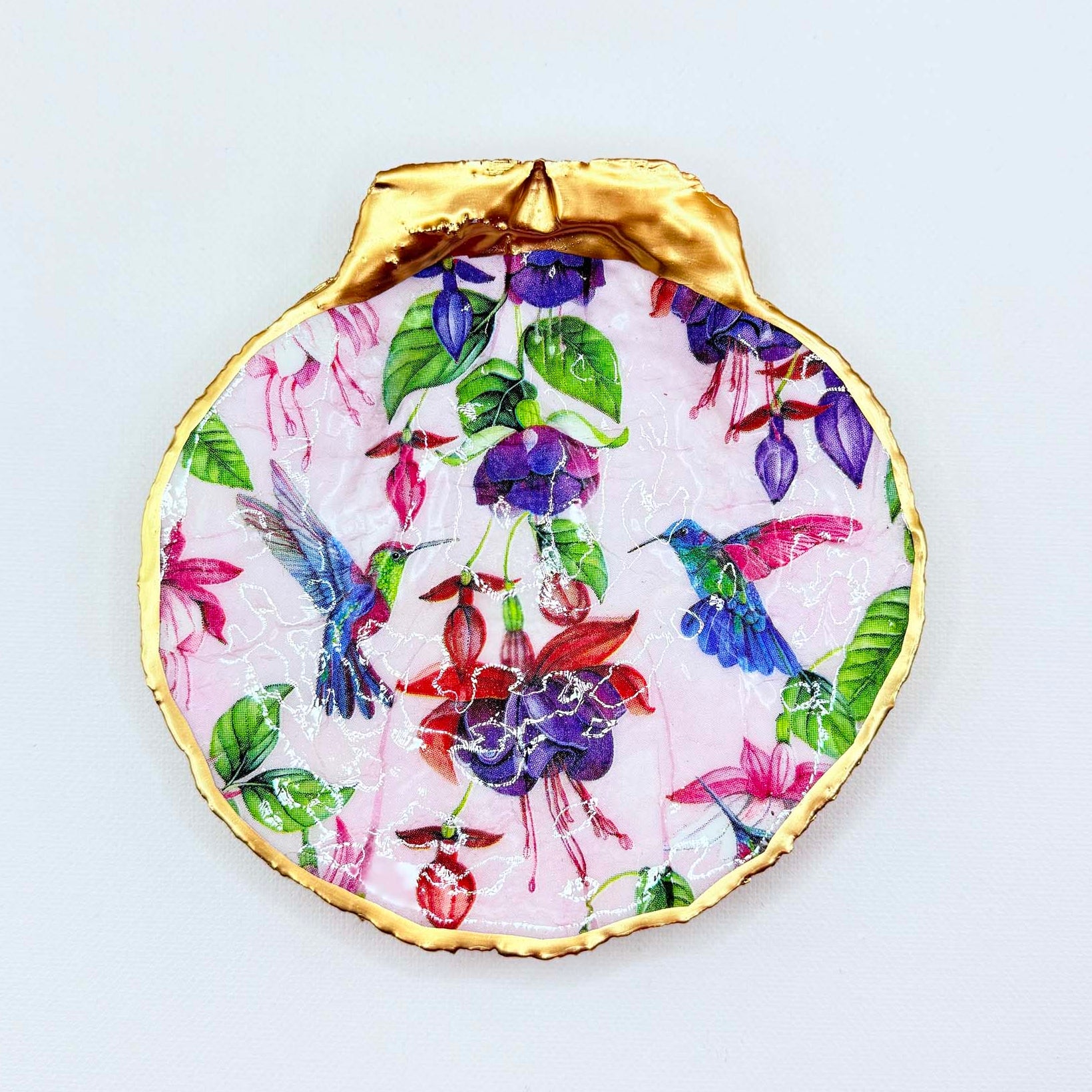 Decorative plate with floral and hummingbird design, gold rim on a white background