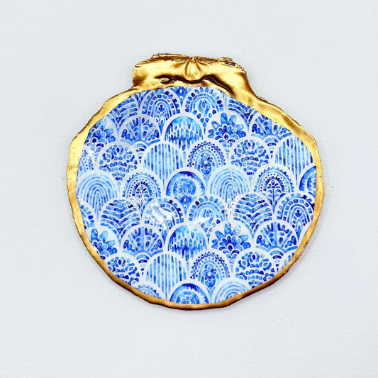 Decorative plate with blue pattern and gold rim on a white background