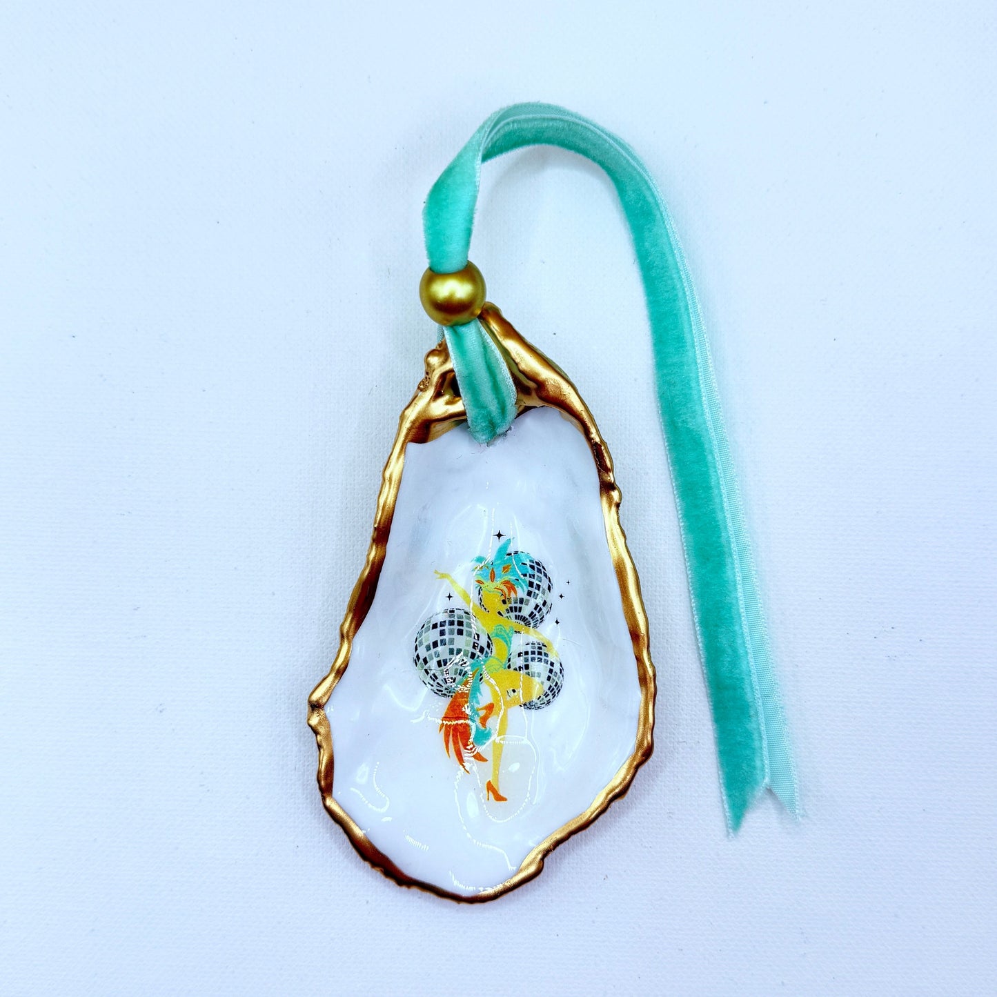 Decorative oyster ornament TS Life of a Showgirl with gold edge and colorful design on a white background