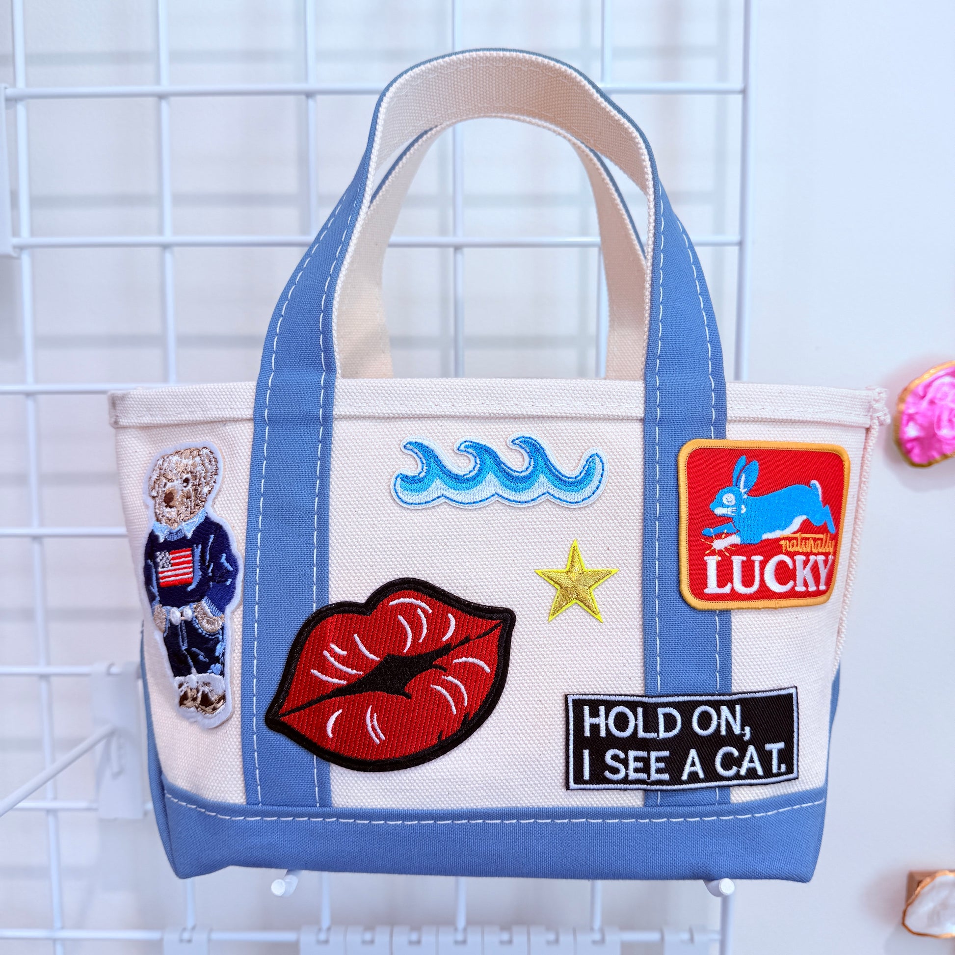 Blue LL Bean Mini Boat and Tote with colorful patches on a white canvas background